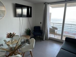 a living room with a table and chairs and a balcony at Incredible Ocean View in Viña del Mar