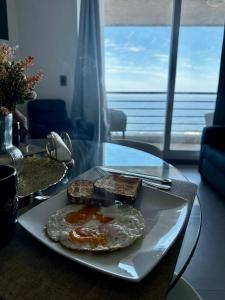 a plate with an egg and toast on a table at Incredible Ocean View in Viña del Mar