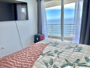 a bedroom with a bed with a view of the ocean at Incredible Ocean View in Viña del Mar +13 photos