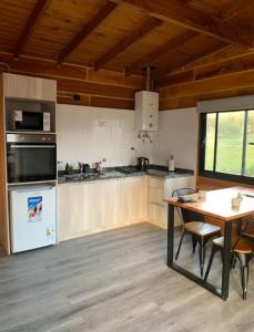 a kitchen with a table and a stove top oven at San Yucac Relax in Los Reartes