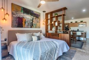 a bedroom with a large bed and a kitchen at Playa Azul Studio - Coco Beach I in Playa del Carmen +27 photos
