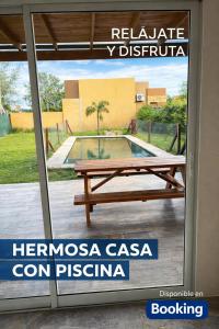 eine Glasschiebetür mit Picknicktisch und Pool in der Unterkunft Casa Victoria - Loft in Roldán
