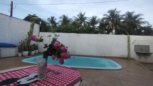 a vase of flowers sitting on a table next to a swimming pool at Casa de Temporada 5 Estrelas in Olímpia +3 photos