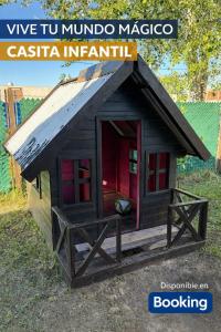 eine kleine hölzerne Hundehütte mit roter Tür in der Unterkunft Casa Victoria - Loft in Roldán