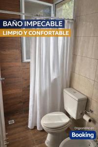 ein Bad mit einem WC und einem weißen Duschvorhang in der Unterkunft Casa Victoria - Loft in Roldán