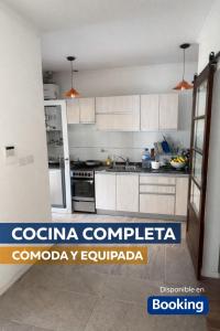 eine Küche mit weißen Schränken und einem Kühlschrank in der Unterkunft Casa Victoria - Loft in Roldán