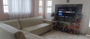 a living room with a couch and a display of toys at Casa de Temporada 5 Estrelas in Olímpia