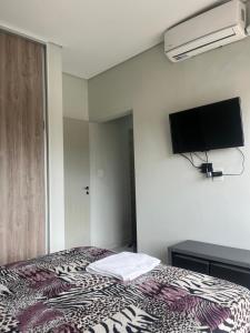 a bedroom with a bed and a flat screen tv at SJ Apart in Corrientes