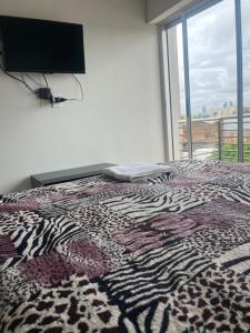 a bedroom with a bed with a television on the wall at SJ Apart in Corrientes