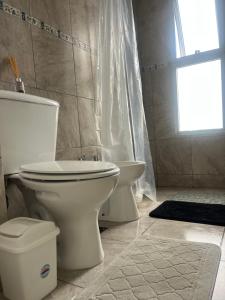 a bathroom with a toilet and a tub and a window at SJ Apart in Corrientes
