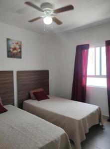 een slaapkamer met twee bedden en een plafondventilator bij Casa Lisboa in Saltillo