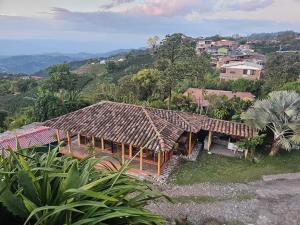 een huis met een rieten dak op een heuvel bij Perla del Ruiz in Manizales +18 foto's