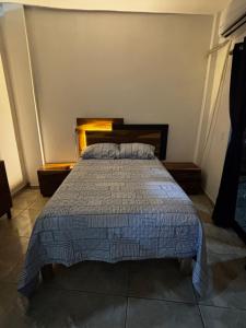 een slaapkamer met een bed met een blauw dekbed bij Adonai in Rincon de Guayabitos