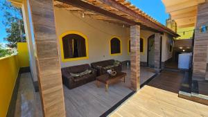 an outdoor patio with a couch and a table at Atlantic Residence - Guaxindiba in São Francisco de Itabapoana