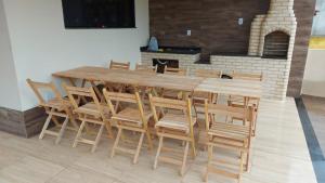 a large wooden table and chairs in a room at Atlantic Residence - Guaxindiba in São Francisco de Itabapoana
