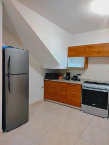 een keuken met een roestvrijstalen koelkast en houten kasten bij Casa Lisboa in Saltillo