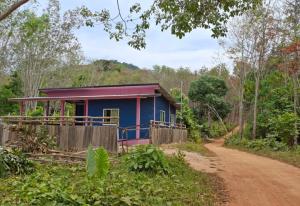 a blue house on the side of a dirt road at Nasin House in Ko Bu Bu