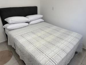 een bed met drie kussens in een kamer bij Casa nova bem aconchegante e tranquila in Biguaçu