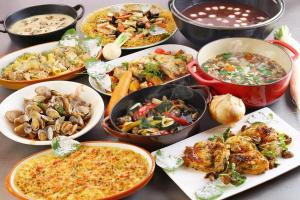 a table with many different dishes of food on it at KAMENOI HOTEL Kamogawa in Kamogawa