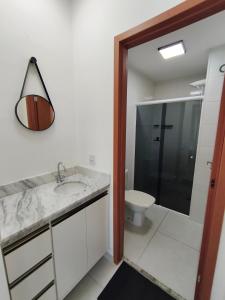 a bathroom with a sink and a toilet and a mirror at 2 Evangelistas Apartamentos in Cachoeira Paulista +42 photos
