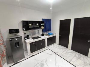 a small kitchen with a sink and a stove at Descanso y Comodidad en Reynosa in Reynosa