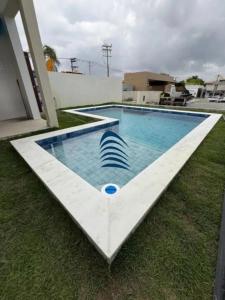 een zwembad in het gras naast een huis bij Casa in Lauro de Freitas