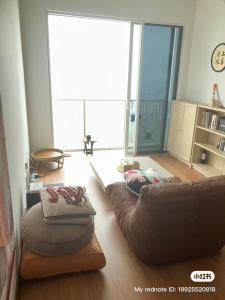 a living room with a leather couch and a large window at Simple and nice unit 3 bed 2 bath in Petaling Jaya +2 photos