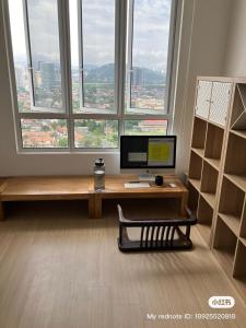 a desk with a computer in a room with a window at Simple and nice unit 3 bed 2 bath in Petaling Jaya