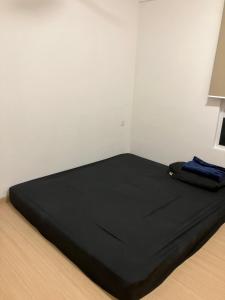 a large black bed in a corner of a room at Simple and nice unit 3 bed 2 bath in Petaling Jaya