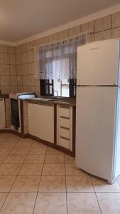 een keuken met een witte koelkast in de kamer bij Pousada Villa&Mar in São Francisco do Sul