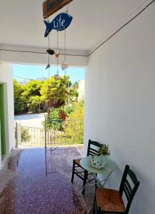 un salon avec une table et une vue sur un portail dans l'établissement Kalimera Aegina, à Agia Marina