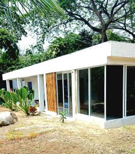 een huis met glazen schuifdeuren in een tuin bij CALABAZO Casa MonoCai in Santa Marta