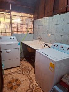 a kitchen with a stove and a washer and a sink at Doucemaison in Tilarán +27 photos