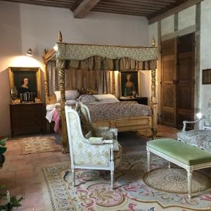 a bedroom with a canopy bed and a chair at Chateau de Gudanes in Château-Verdun