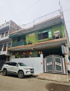 una macchina bianca parcheggiata di fronte a un edificio di SUKH DHAM HOMeSTAy a Prayagraj
