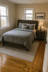 una camera da letto con un letto con un tappeto e due finestre di The Saratoga Beachhouse a Saratoga Springs Altre 5 foto