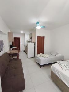 a living room with two beds and a couch at 2 Evangelistas Apartamentos in Cachoeira Paulista