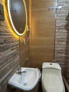a bathroom with a white toilet and a sink at Hospedaje Ariana in Supe