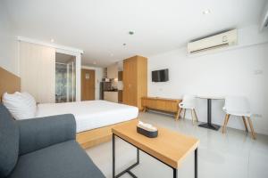 a bedroom with a bed and a couch and a table at Fourium Pattaya Hotel and Serviced Residence in Pattaya South +93 photos