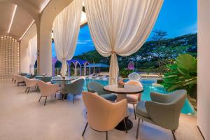a restaurant with chairs and tables and a pool at Mercure Xishuangbanna in Jinghong