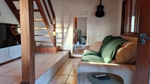 a living room with a couch and a staircase at Vila no Rosa Hospedaria in Praia do Rosa