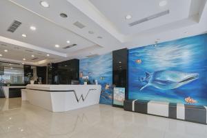 a lobby with a fish painting on the wall at Wecan Hotel in Kaohsiung