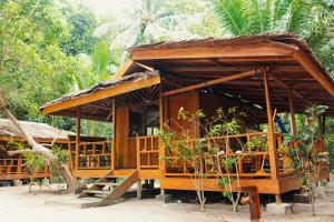ein kleines Holzgebäude mit einer Treppe davor in der Unterkunft Harmony Bay Resort and Dive Center in Wakai