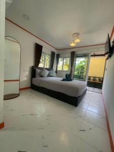 a bedroom with a large bed and some windows at Vannana House Ko Lanta in Ko Lanta