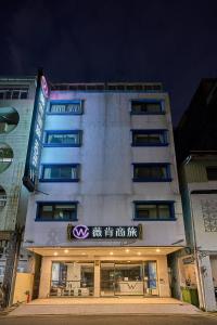 a building with a sign on the side of it at Wecan Hotel in Kaohsiung