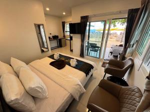 a hotel room with a bed and a chair at Naiyang Discovery Beach Resort in Nai Yang Beach