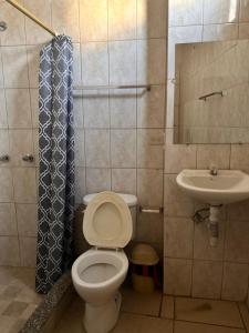 a bathroom with a toilet and a sink at Hostal Luxury Place in Bahía de Caráquez