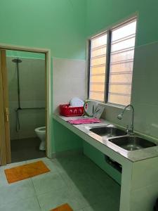 een badkamer met een wastafel en een toilet bij Mahsuri Dorm, Roomstay & Homestay Langkawi in Ulu Melaka