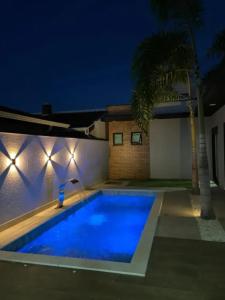 a swimming pool with a fountain in front of a house at Casa de Luxo temporada in Paulínia