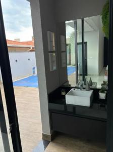 a bathroom with a sink and a mirror at Casa de Luxo temporada in Paulínia +9 photos